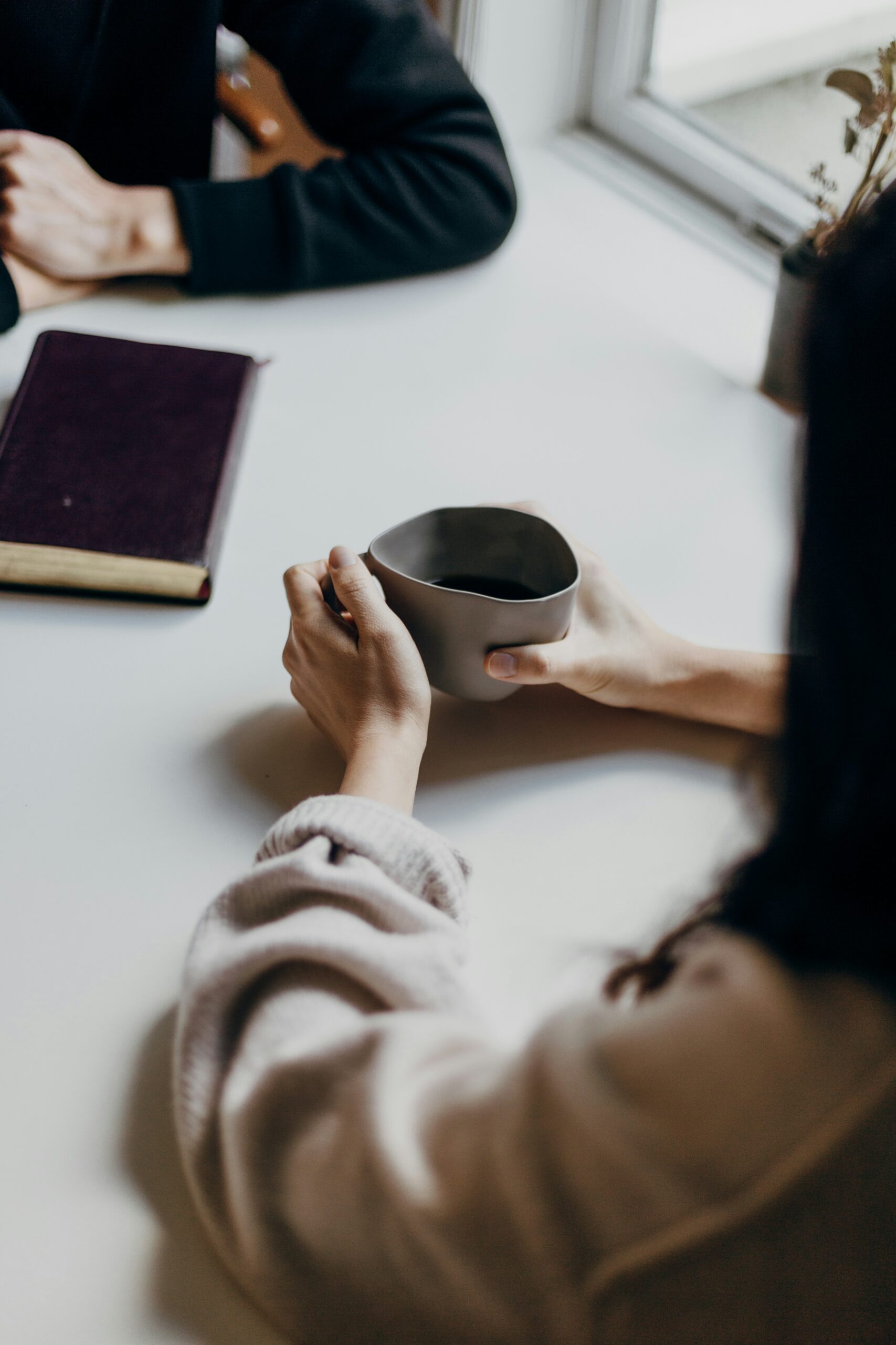 Therapist sitting across from client with a cup of coffee